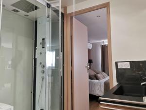 y baño con ducha acristalada y lavamanos. en Appart Hotel Spa Perpignan en Perpiñán