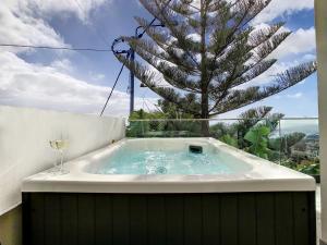 a hot tub with a glass of wine next to a tree at Casa Erbozeta by LovelyStay in Funchal