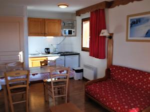 a living room with a couch and a table and a kitchen at Appartement La Joue du Loup, 2 pièces, 6 personnes - FR-1-504-86 in Le Dévoluy