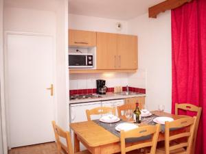 eine Küche mit einem Holztisch mit Stühlen und einem Esszimmer in der Unterkunft Appartement Puy-Saint-Vincent, 3 pièces, 6 personnes - FR-1-504-106 in Puy-Saint-Vincent