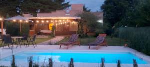 a backyard with a pool with chairs and a table at La Ernestina in Villa Giardino