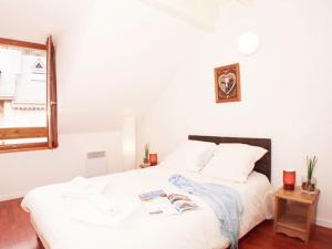 a white bed with two books on it in a bedroom at Appartement Vignec, 2 pièces, 6 personnes - FR-1-504-178 in Vignec