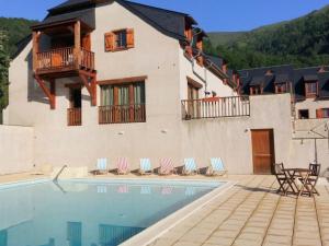 a house with a swimming pool in front of a building at Appartement Vignec, 2 pièces, 6 personnes - FR-1-504-178 in Vignec