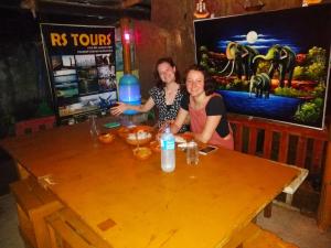 a man and a woman sitting at a wooden table at Rosa Shashi Cabanas in Galle