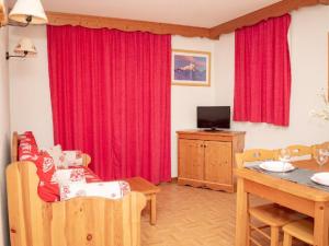 ein Wohnzimmer mit roten Vorhängen und einem Tisch in der Unterkunft Appartement Puy-Saint-Vincent, 2 pièces, 6 personnes - FR-1-504-170 in Puy-Saint-Vincent