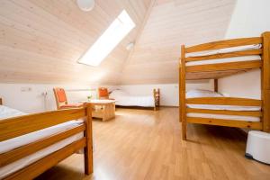 a bedroom with two bunk beds and a desk at Hostel Kronotop in Triglav National Park in Log pod Mangartom