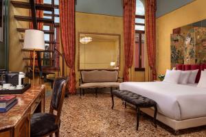 una camera con letto, scrivania e sedia di NH Collection Grand Hotel Palazzo Dei Dogi a Venezia