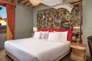 a large white bed in a room with a painting at NH Collection Grand Hotel Palazzo Dei Dogi in Venice