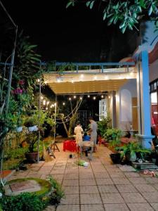 2 personnes debout dans un jardin la nuit dans l'établissement Ly's homestay, à Gia Nghĩa
