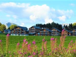 um campo de flores com casas ao fundo em Appartement La Joue du Loup, 2 pièces, 6 personnes - FR-1-504-160 em Le Dévoluy