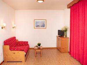 a living room with a red couch and a television at Appartement Puy-Saint-Vincent, 2 pièces, 4 personnes - FR-1-504-260 in Puy-Saint-Vincent
