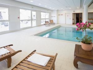 a swimming pool with two chairs and a table at Appartement Puy-Saint-Vincent, 2 pièces, 4 personnes - FR-1-504-260 in Puy-Saint-Vincent