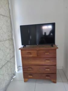 a tv sitting on top of a wooden dresser at Espaço Mangue House in Barra de Guaratiba