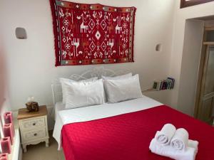 a bedroom with a red and white bed with towels on it at Chelidonofolia in Skhinokápsala