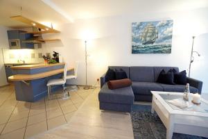 sala de estar con sofá azul y cocina en Alt_Ahlbeck, en Ahlbeck