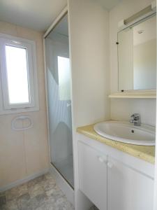 a white bathroom with a sink and a shower at VAL ST GEORGES in Saint-Georges-de-Luzençon