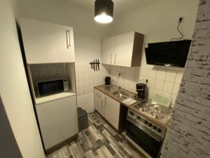 a small kitchen with a sink and a microwave at Schickes 1,5 Zimmer-Cityapartment Bielefeld Mitte in Bielefeld