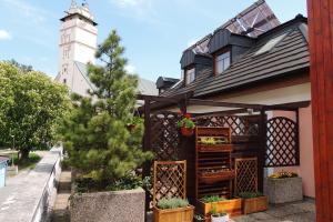 a house with a lighthouse in the background at Hotel Club in Kežmarok