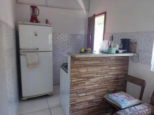 a kitchen with a white refrigerator and a counter at Espaço Mangue House in Barra de Guaratiba