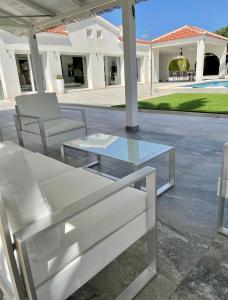 einen Glastisch und zwei Stühle auf einer Terrasse in der Unterkunft Villa Pyeranch in Torrevieja