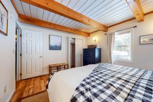 a bedroom with a bed and a wooden ceiling at Deer Run Retreat in Gilford