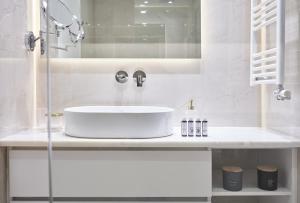biała łazienka z umywalką i lustrem w obiekcie Urban Heights 3BD Apt, next to Hilton w Atenach +26 zdjęć