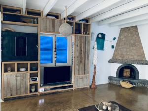 a living room with a large television and a fireplace at Casa Mariposa in Es Pujols