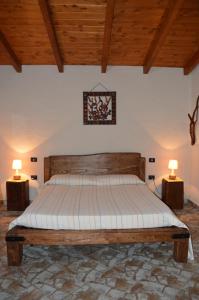 1 dormitorio con 1 cama con 2 lámparas en 2 mesas en Giardino degli Ulivi, en Gonnesa