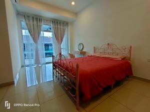 a bedroom with a red bed and a window at Ngio Homestay Batu Pahat in Batu Pahat +9 photos