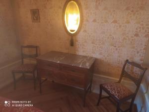 a room with two chairs and a dresser and a lamp at Quinta da Lua Nova in Travancinha