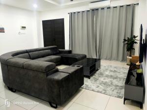 a living room with a brown couch and a table at Ngio Homestay Batu Pahat in Batu Pahat