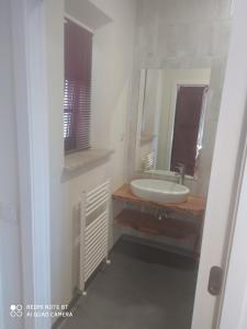 a white bathroom with a sink and a mirror at Quinta da Lua Nova in Travancinha
