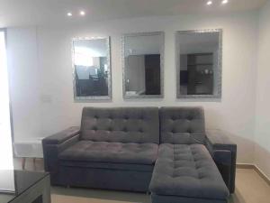 a living room with a couch and two mirrors at Vera's Apto 1002 - WAIWA HOST in Bucaramanga