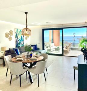 ein Wohnzimmer mit einem Tisch, Stühlen und einem Sofa in der Unterkunft Luxury 3 Bedroom Apartment 300m from the Beach in Fuengirola