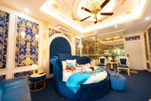 ein Schlafzimmer mit einem blauen Bett, Stühlen und einem Tisch in der Unterkunft King's Hotel Linh Đàm 1 in Hanoi