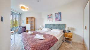 ポビエロボにあるApartamenty Sun & Snow Pineaのベッドルーム1室(赤毛布付きの大型ベッド1台付)