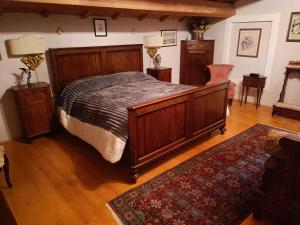 1 dormitorio con cama grande de madera y alfombra en Alloggio Alla Collina, en Arcugnano
