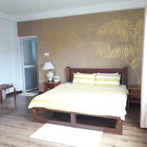 a bedroom with a large bed with yellow pillows at Medalin Lake Gregory in Nuwara Eliya