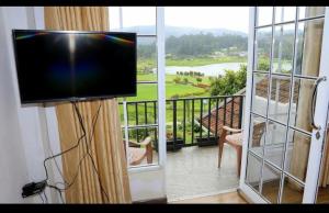 Camera con TV a schermo piatto e balcone. di Medalin Lake Gregory a Nuwara Eliya