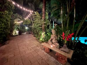 un jardín con un banco y plantas y luces en Casa Da Praia, en Candolim