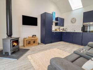 a living room with a couch and a fireplace at 3 Mountain View in Llangefni