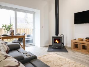 a living room with a couch and a fireplace at 3 Mountain View in Llangefni