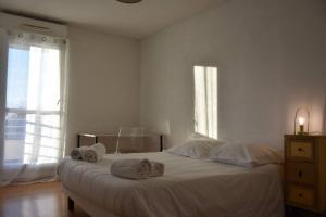 - une chambre blanche avec un lit et des serviettes dans l'établissement T3 Le Perrier, à Olivet