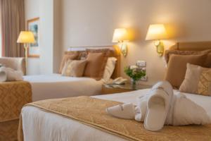 una habitación de hotel con dos camas con zapatos. en Gran Hotel Los Abetos en Santiago de Compostela
