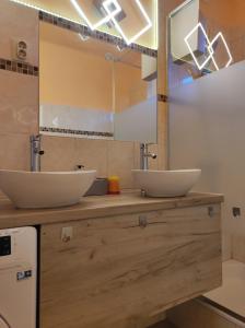 - 2 lavabos sur un comptoir en bois dans la salle de bains dans l'établissement Jázmin Apartman, à Szeged