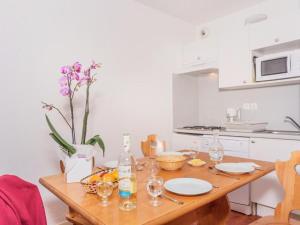 een keuken met een houten tafel met borden en glazen bij Appartement Vignec, 3 pièces, 8 personnes - FR-1-504-57 in Vignec