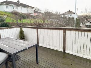 eine Holzterrasse mit einem Tisch und einem Zaun in der Unterkunft Modern villa near Gothenburg in Göteborg