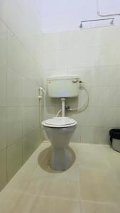 a bathroom with a white toilet in a room at Hotel Caveri Inn in Madikeri