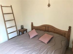 - une chambre avec un lit et 2 oreillers roses dans l'établissement Chalet mitoyen rénové 3 pièces, 7 pers, terrasse, parking, animaux admis - FR-1-504-69, à Saint-Étienne-en-Dévoluy 13 autres photos