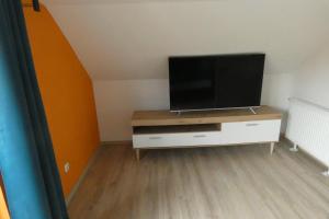 una sala de estar con TV de pantalla plana en una cómoda en Holiday, en Schwandorf